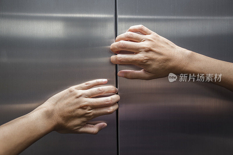 女人的手试图阻止关闭的电梯门