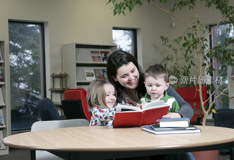 快乐的妈妈和孩子们在图书馆里读书