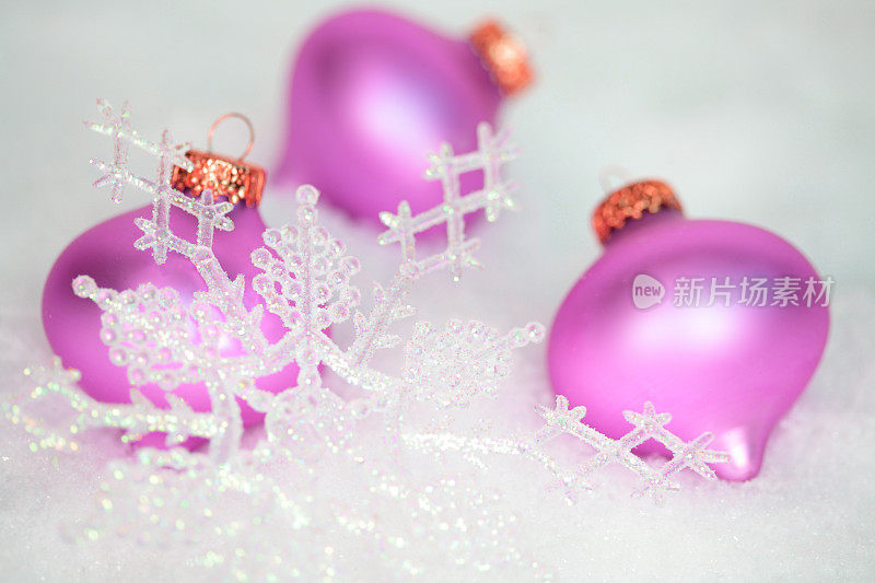 圣诞节:闪闪发光的白色雪花上点缀着紫红色的装饰