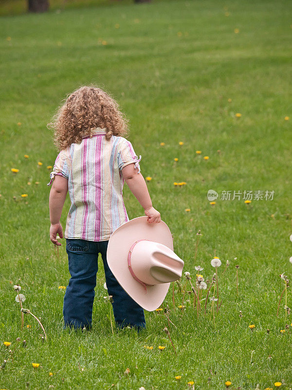 拿着帽子的年轻女牛仔