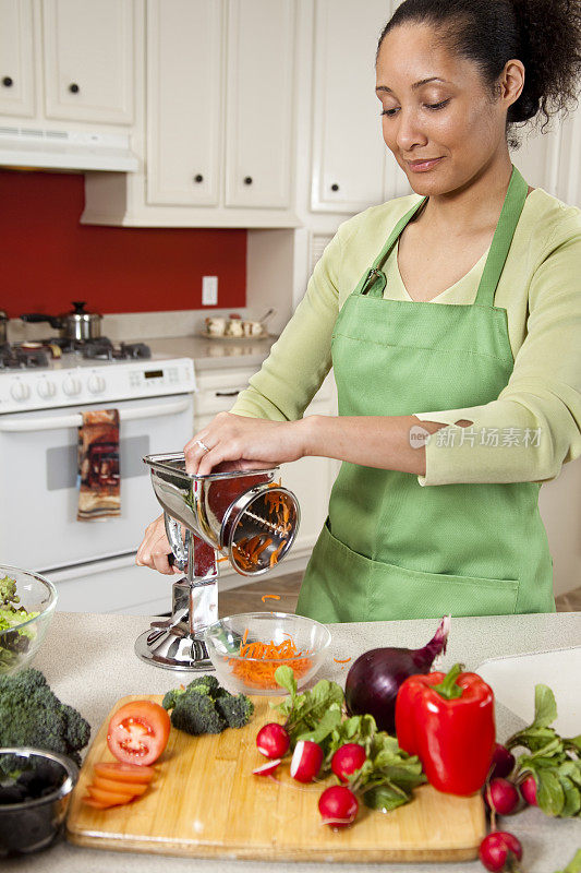 在厨房里磨胡萝卜的女人。在切菜板上种菜。