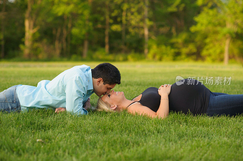 丈夫亲吻躺在外面怀孕的妻子