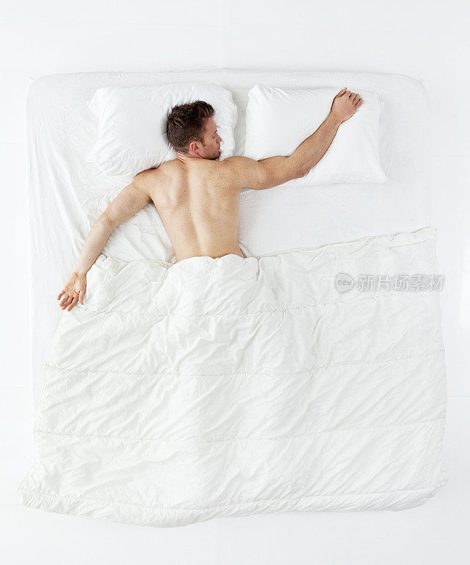上图是一个肌肉发达的男人睡在床上