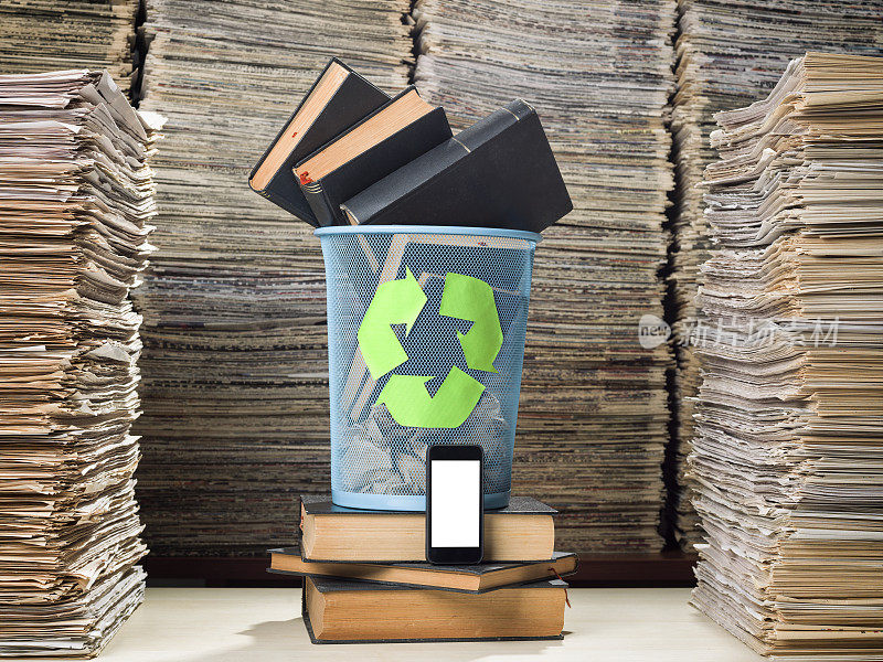 智能手机夹在一大堆文件和垃圾桶里的书中