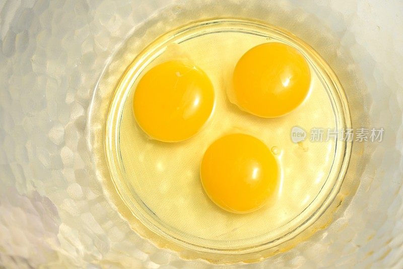 三个完美的新鲜鸡蛋放在玻璃碗里