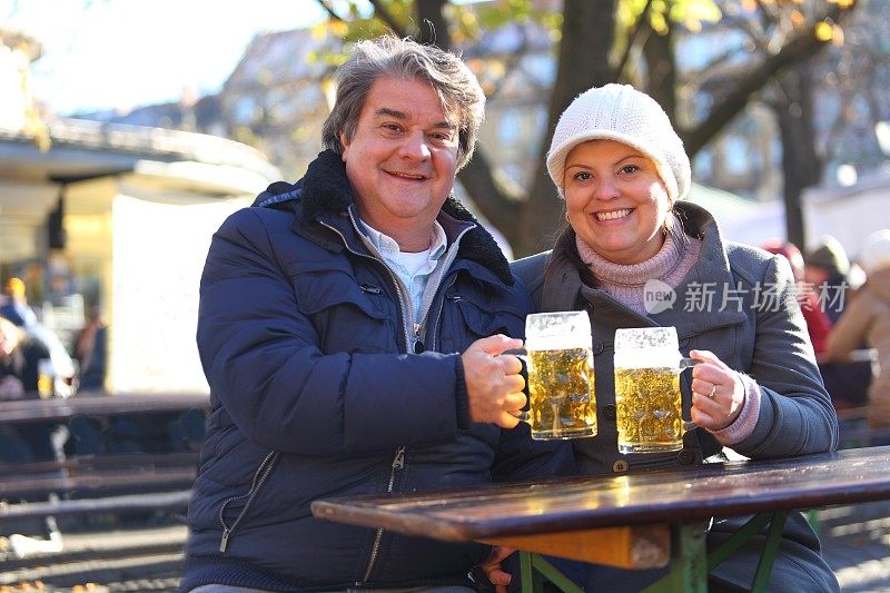 一对夫妇在慕尼黑的啤酒花园分享啤酒