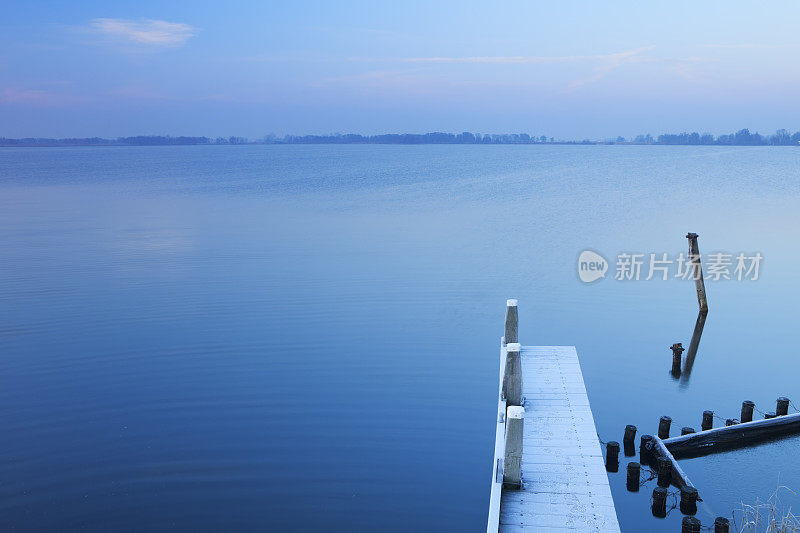 在一个霜冻的冬日早晨，码头在静静的湖面上