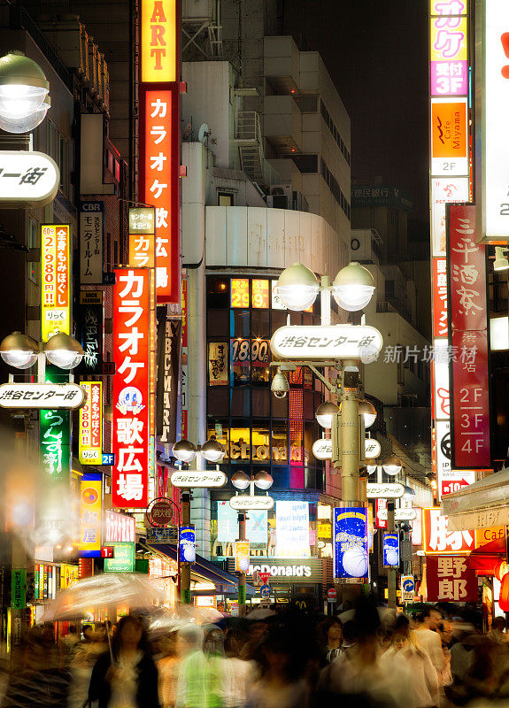 雨夜，人们在日本东京涩谷区购物