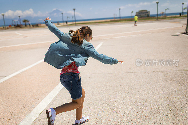 十几岁的女孩在公园滑冰摔倒了