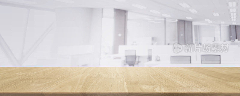 木质桌面和模糊的散景办公室室内空间背景-可以用来展示或蒙太奇您的产品。