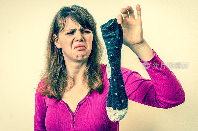 女人拿着脏臭的袜子