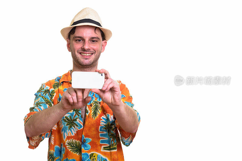 摄影棚里的年轻快乐的游客微笑着用手机拍照