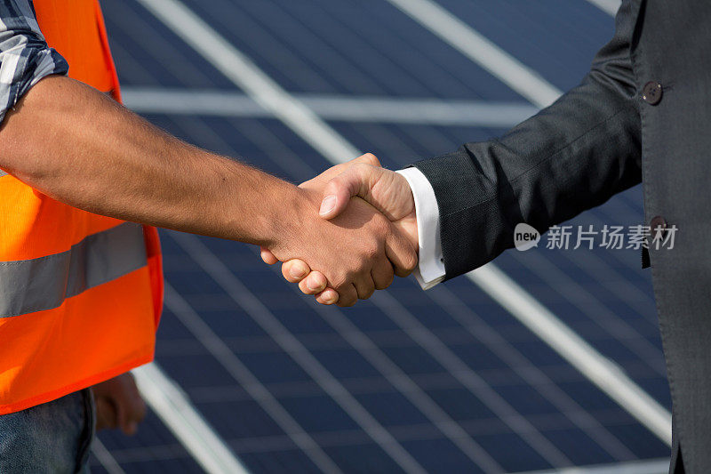 工头和商人在太阳能站握手。