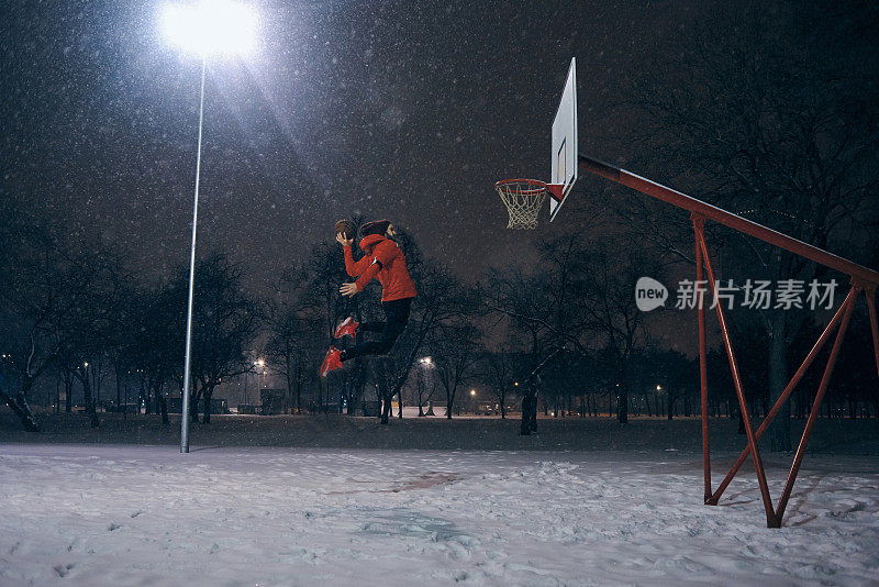 一个运动员在寒冷的冬夜在户外灌水