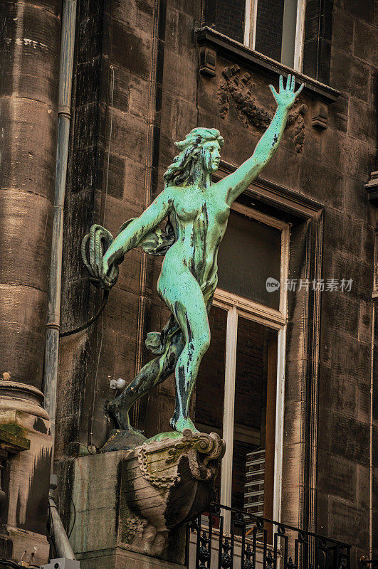 安特卫普阴天里一座建筑里的女性雕像的特写镜头。