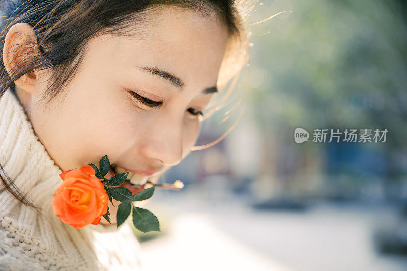 亚洲女孩在太阳耀斑下的红花，上海，中国