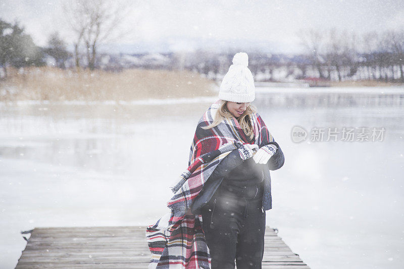 雪地里穿着格子毯子的年轻女子