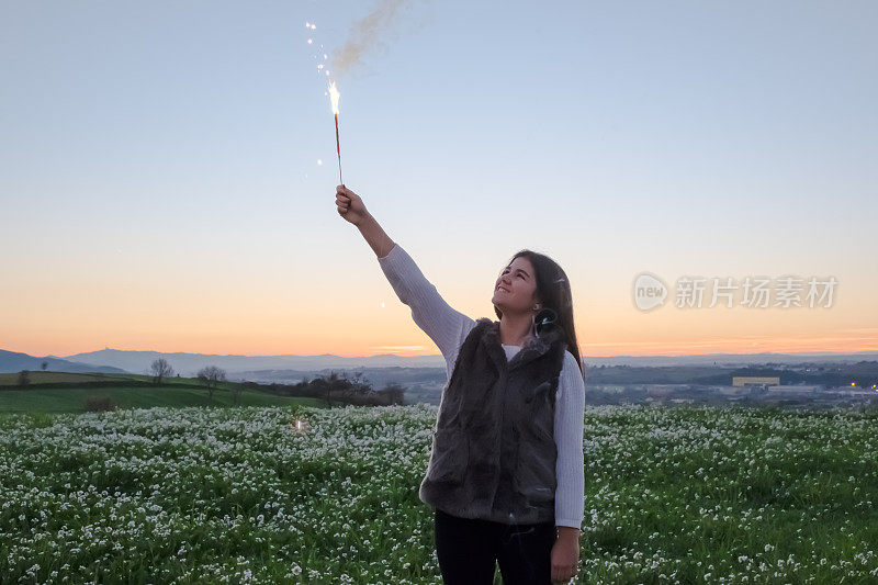 年轻的女孩在户外拿着烟花