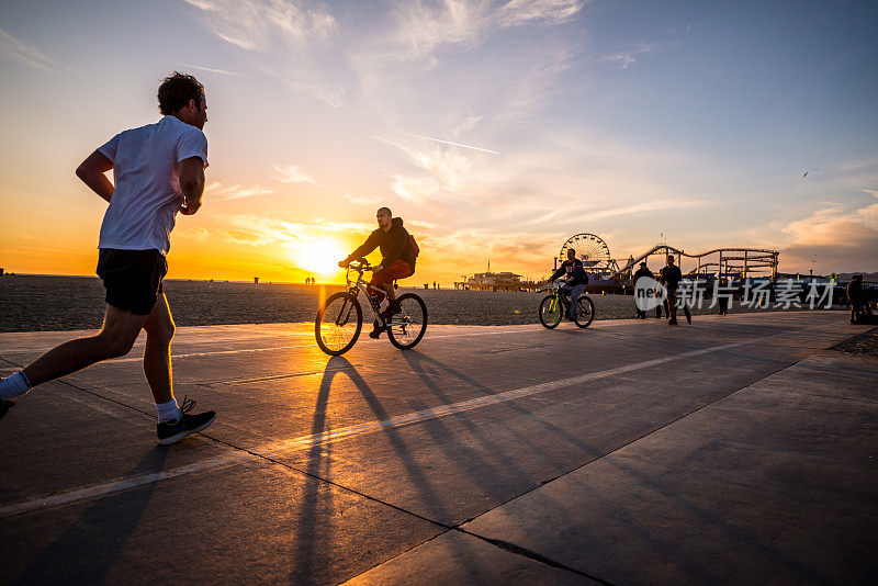美国加州圣塔莫尼卡海滩上骑自行车和慢跑的人们