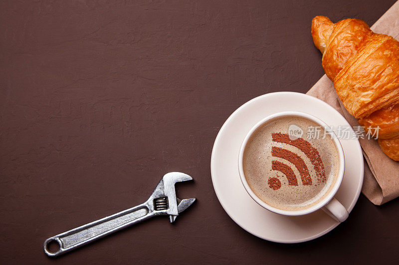 一杯泡沫上有WiFi标志的咖啡。免费接入互联网WiFi。我喜欢喝咖啡的时候吃牛角面包。维修服务理念。技术支持、扳手
