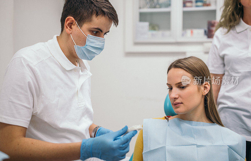 牙医向病人展示义齿