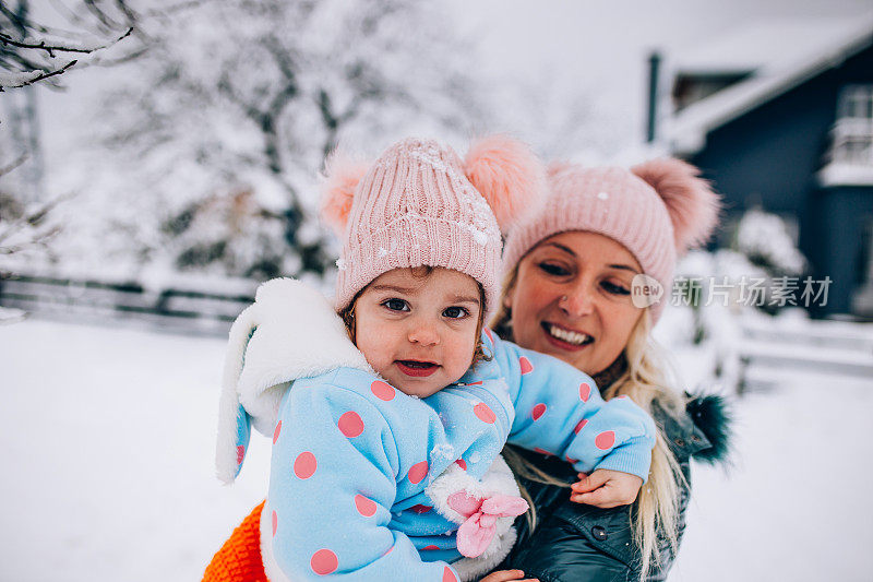 快乐的妈妈喜欢和她的孩子在雪地里玩