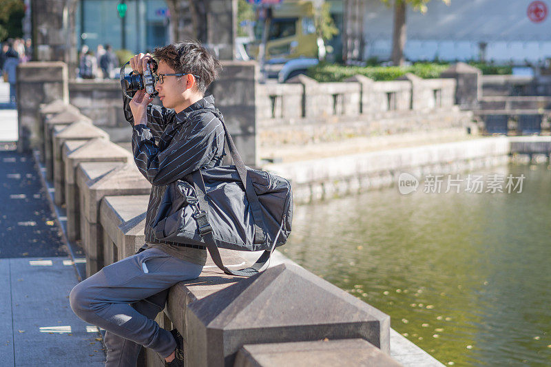 年轻的亚洲男子和日本朋友寻找旅游地点使用手机和花时间在亚洲旅行