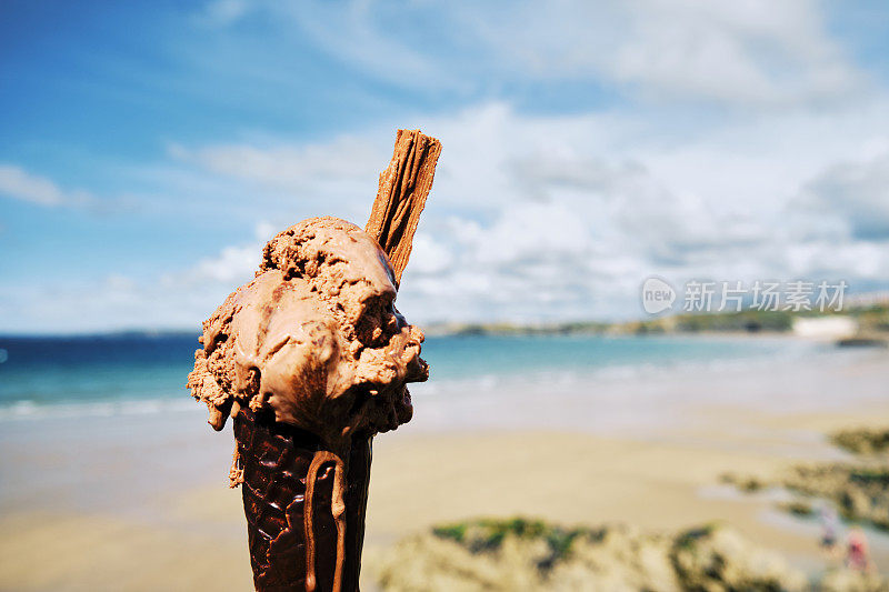 正在融化的巧克力冰淇淋，纽基，康沃尔在一个阳光明媚的六月天托万海滩。