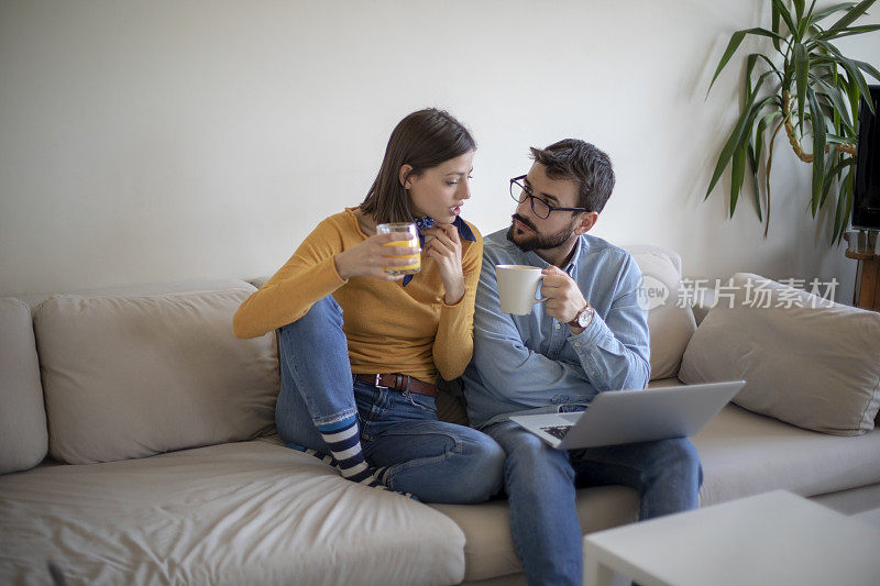 年轻夫妇在客厅里用一台电脑