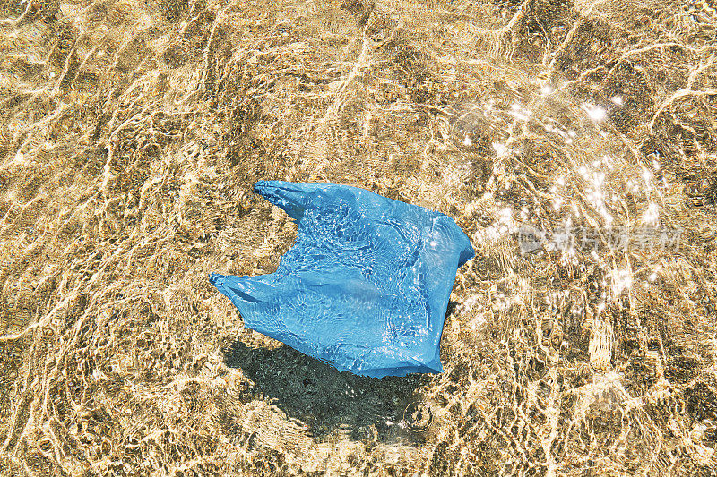 污染，一次性塑料袋漂浮在田园诗般的浅海中。