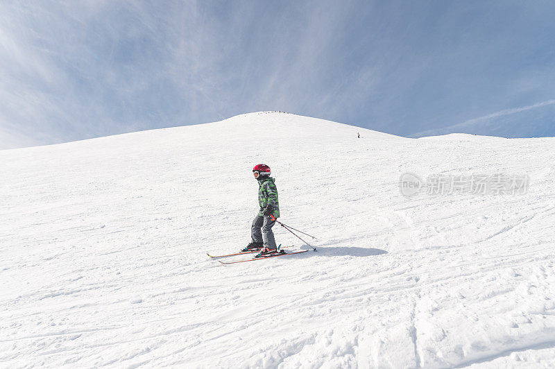 男孩从山上滑雪下来