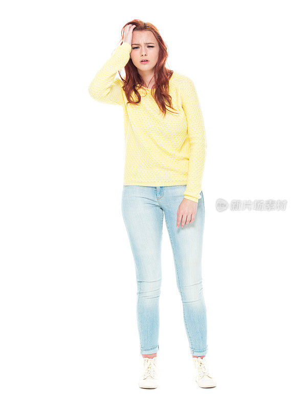 穿着黄色毛衣和浅蓝色牛仔裤的可爱年轻女性