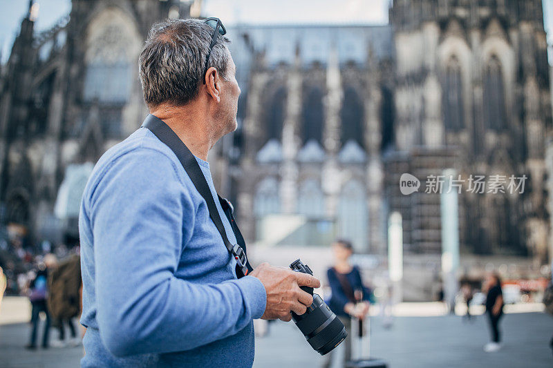 一个带着数码相机的成熟男人在街上