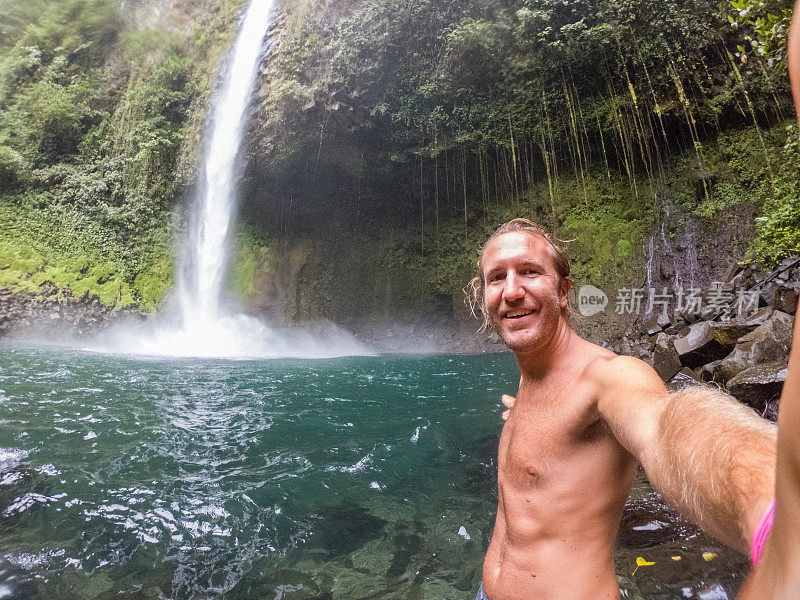 一名年轻人在哥斯达黎加的瀑布中自拍