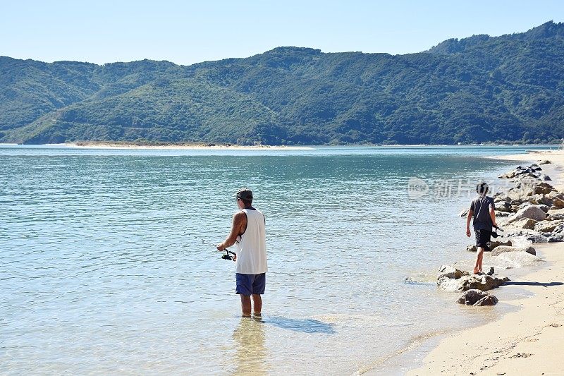 夏天，孩子和父亲在海边钓鱼