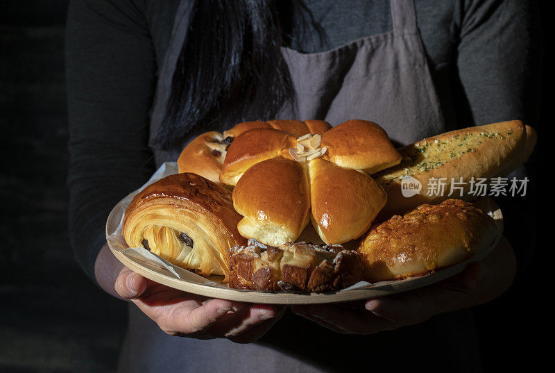 面包师拿着各种面包