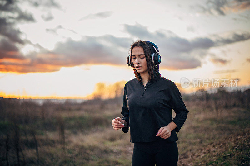 年轻女子一边跑步一边听音乐