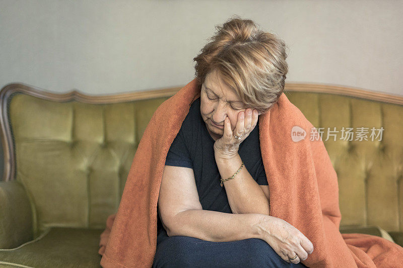 可悲的成熟女人65-70岁孤零零地坐在家里
