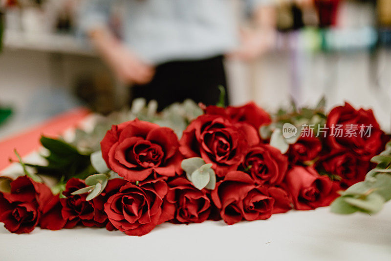 花店的白桌上放着红玫瑰