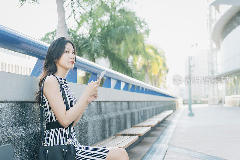 忙碌的女商人在城市里使用智能手机