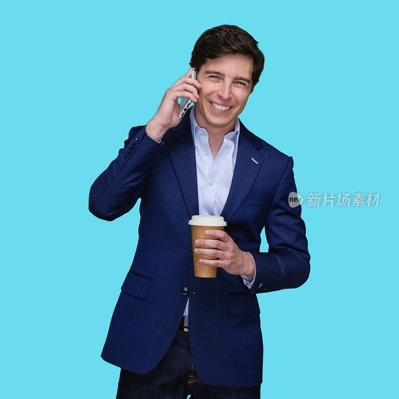 蓝色背景的白人年轻男性，穿着夹克，拿着咖啡杯，使用手机