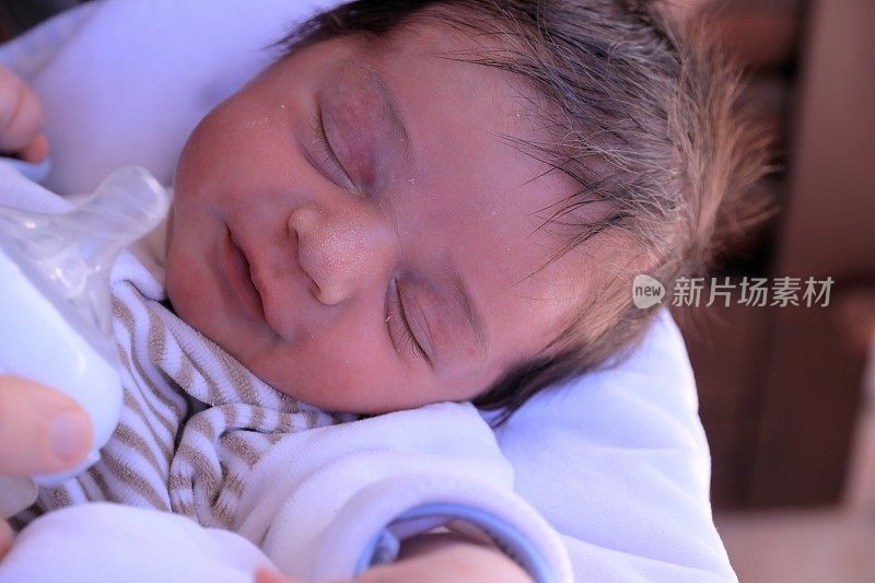 父亲正在给新生婴儿喂奶