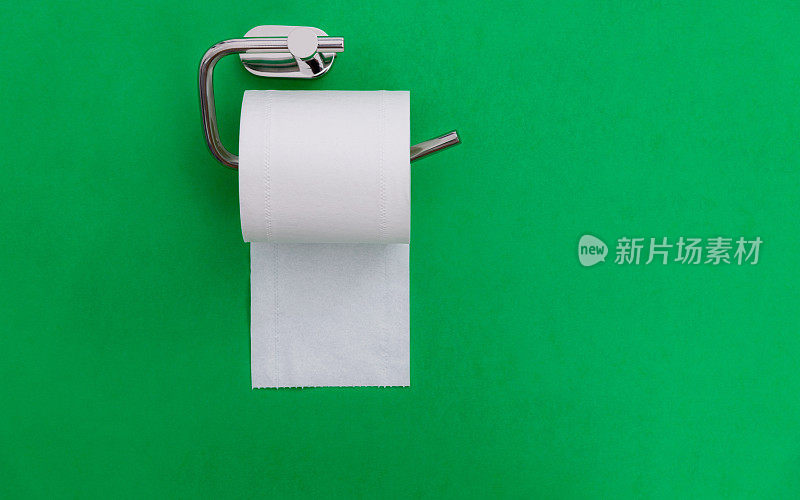 一卷白色卫生纸挂在绿色背景上