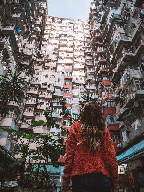 香港，一名女子抬头看着拥挤的公寓
