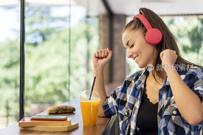 一个漂亮的女人用耳机听手机里的音乐