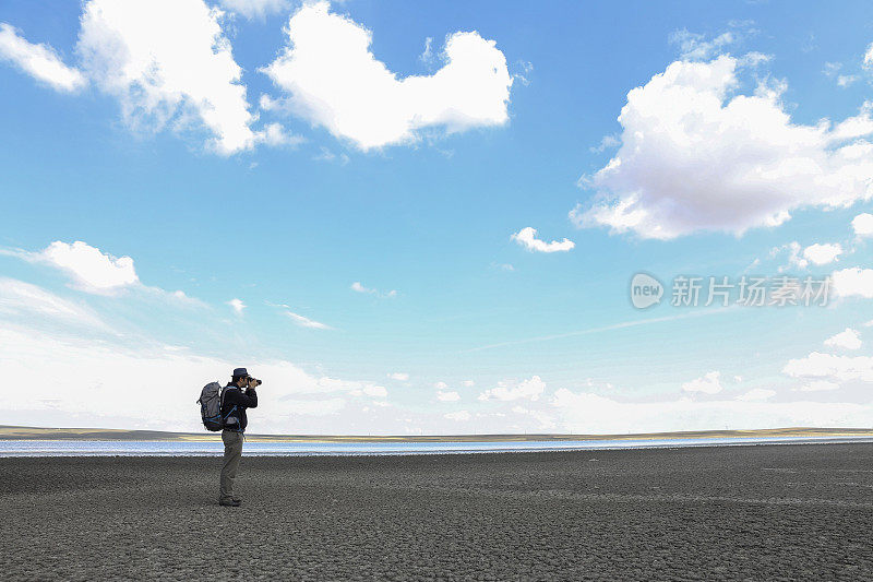 摄影师在大自然中拍照。蓝色的天空背景