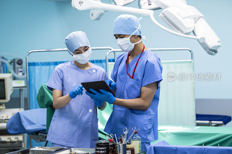 女医生和外科医生在手术室里检查数字病历