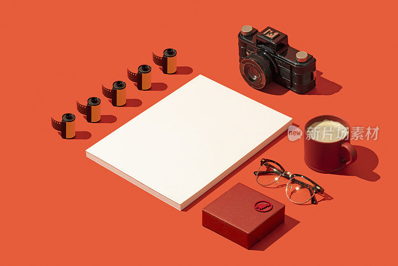杂志封面模型的红色背景与礼盒，相机，胶卷，眼镜和咖啡
