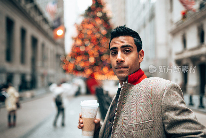 一名印度商人正在华尔街看圣诞报纸