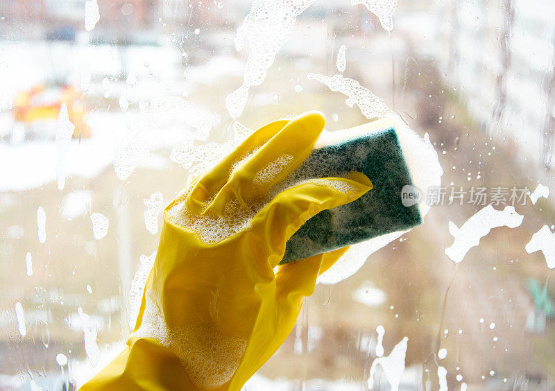 春天用洗涤剂和海绵清洗脏的窗玻璃。家里清洁